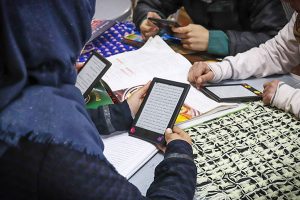 Photo: Refugees reading on Kindles