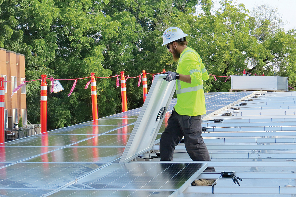 A worker installs solar panels on the roof of Ledding Library in Milwaukie, Oregon. Photo: Katie Newell/Ledding Library in Milwaukie, Oregon