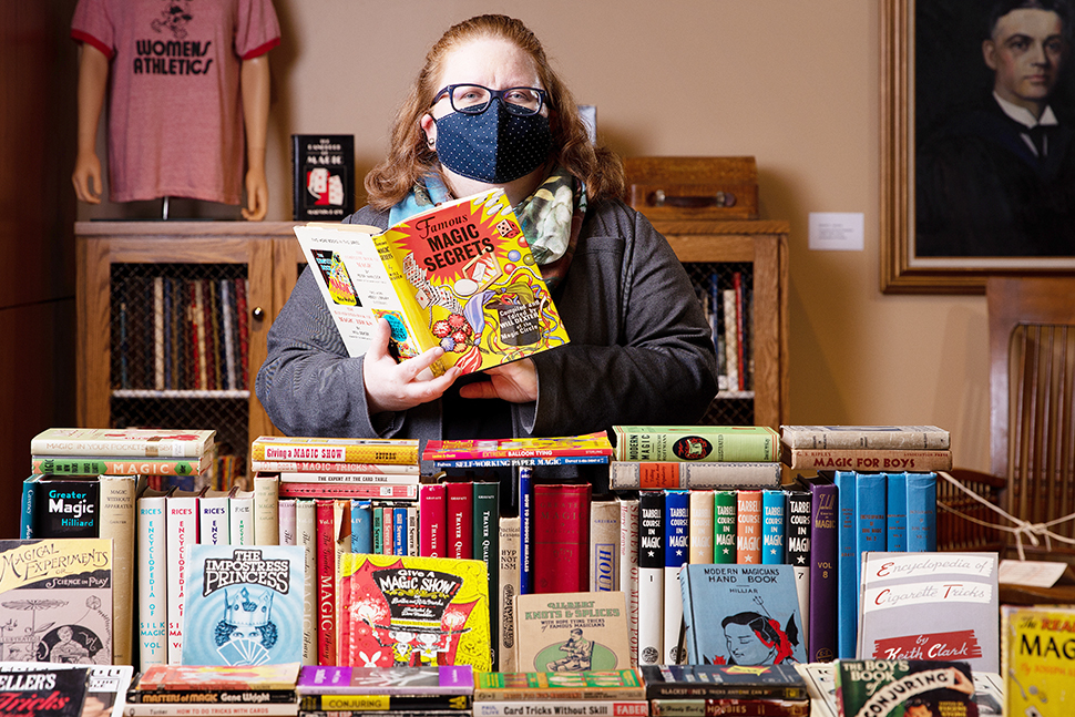 Amy Schindler, director of archives and special collections at University of Nebraska at Omaha (UNO) Libraries, holds a magic book from the Omaha (Neb.) Magical Society collection. (Photo: University of Nebraska at Omaha)