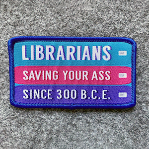 Librarians Saving Your Ass Since 300 BCE patch in teal, hot pink, and purple