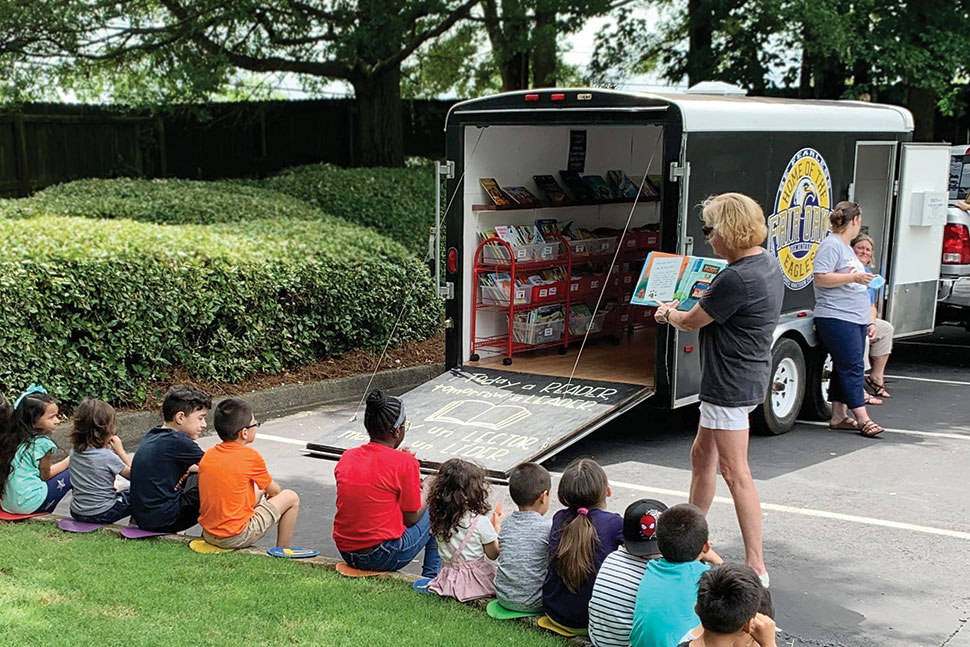 Valerie Wagley, counselor at Fair Oaks Elementary School in Cobb County, Georgia, reads to kids at a bookmobile stop in summer 2020. Photo: Kelli Wood