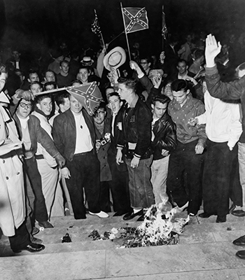 University of Alabama students are seen burning NAACP literature on the county courthouse steps.
