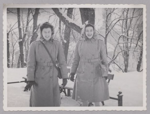 Two women (Sylvia and Sylvia) standing next to each other in thick snow with trees behind them