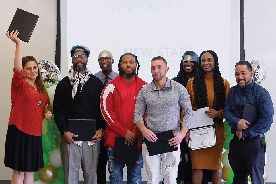 Eight people standing with certificates in their hands