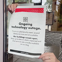 A notice posted on the door of the Seattle Public Library explaining an ongoing technology outage to patrons